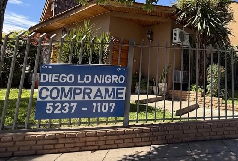 Su cartel azul en la reja de un PH de Ciudad Jardín: DIEGO LO NIGRO, CÓMPRAME, 5237-1107